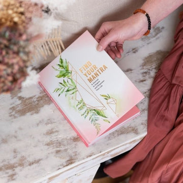 Find Your Manatra book on wooden bench with woman opening front cover
